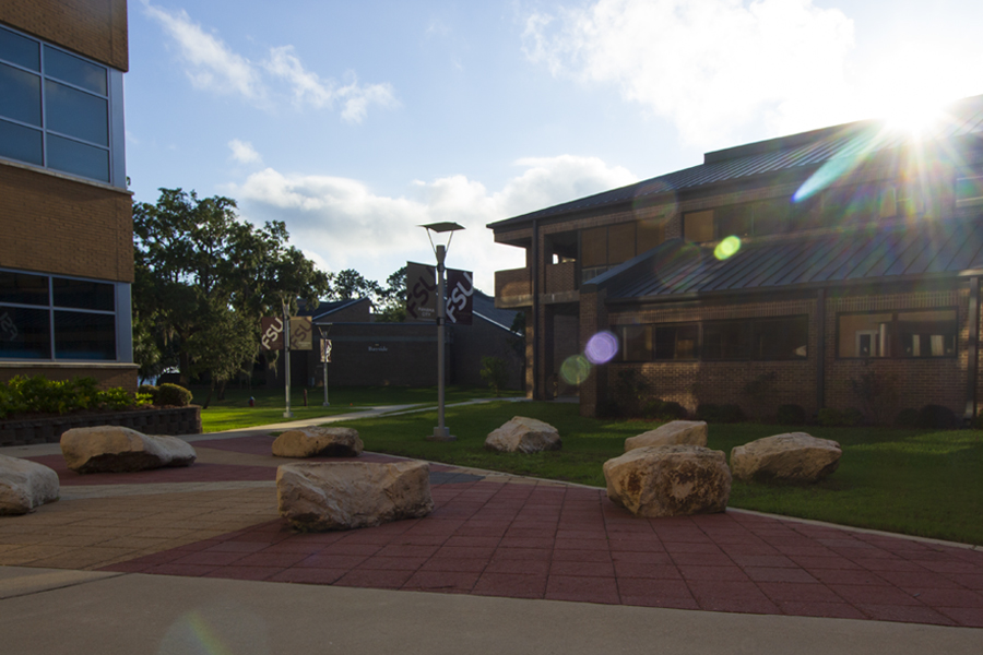 Four Crossed Logs patio with large rocks to sit on between Holley Academic Center and Faculty Building