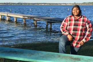 April Moore with dock and water in the backgrouond